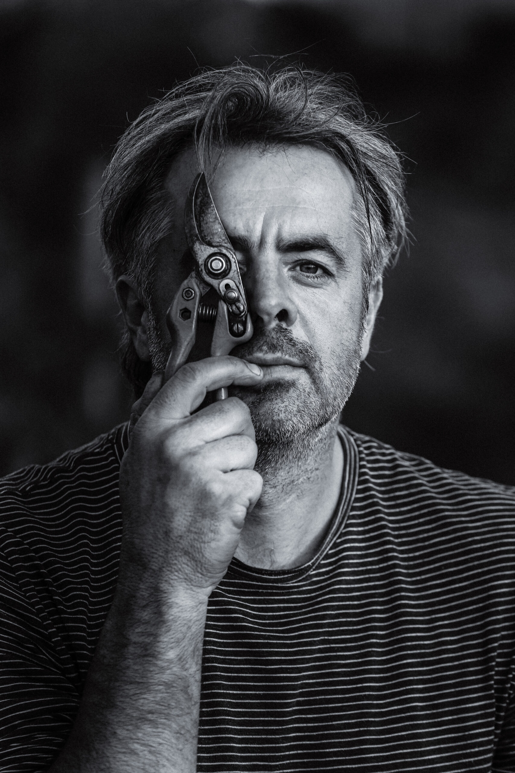 Németh János Pincészet: „Von der Lage, spontan“ Németh János hält eine Rebschere vor das Auge – Schwarz-Weiß-Porträt vom Weingut Németh János Pincészet, Szekszárd